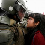 Demonstratorka se ustavi pred policistom med protestom ob obeležitvi vojaškega udara v Čilu. 11. september 2016, Santiago, Čile.