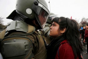 Demonstratorka se ustavi pred policistom med protestom ob obeležitvi vojaškega udara v Čilu. 11. september 2016, Santiago, Čile.