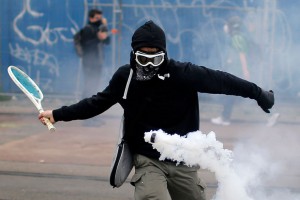 Protestnik uporabi teniški lopar, da odbije posodo s solzivcem med demonstracijami proti predlagan reformi delovne zakonodaje. 2. junij 2016, Nantes, Francija.